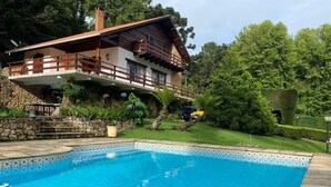 Una casa con piscina, escalones de piedra y jardín.