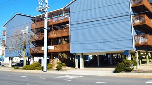 Un hôtel à plusieurs étages doté de balcons, d’un parking et offrant une vue sur un ciel dégagé.