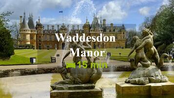 Manor de Waddesdon con una gran fuente y estatuas en primer plano.