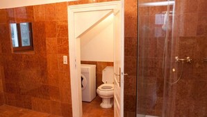 A bathroom with a glass-enclosed shower, a washing machine, and a toilet. - Raisa Superior Apartment with 2 bedrooms, 2 terraces and marble bathroom  (Pressbaum)