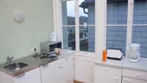 A compact kitchen with white cabinets, a stainless steel sink, a toaster, and a coffee maker. - Raisa Superior Apartment with 2 bedrooms, 2 terraces and marble bathroom  (Pressbaum)