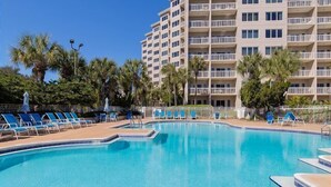A swimming pool with lounge chairs and a multi-story building in the background. - Rate Reduced! Tops'l Condo -  Walk to Beach, Tropical Pool, Balcony. (Miramar Beach)