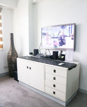 Relax in this stylish living room with a flat-screen TV, entertainment unit, and comfortable seating area.