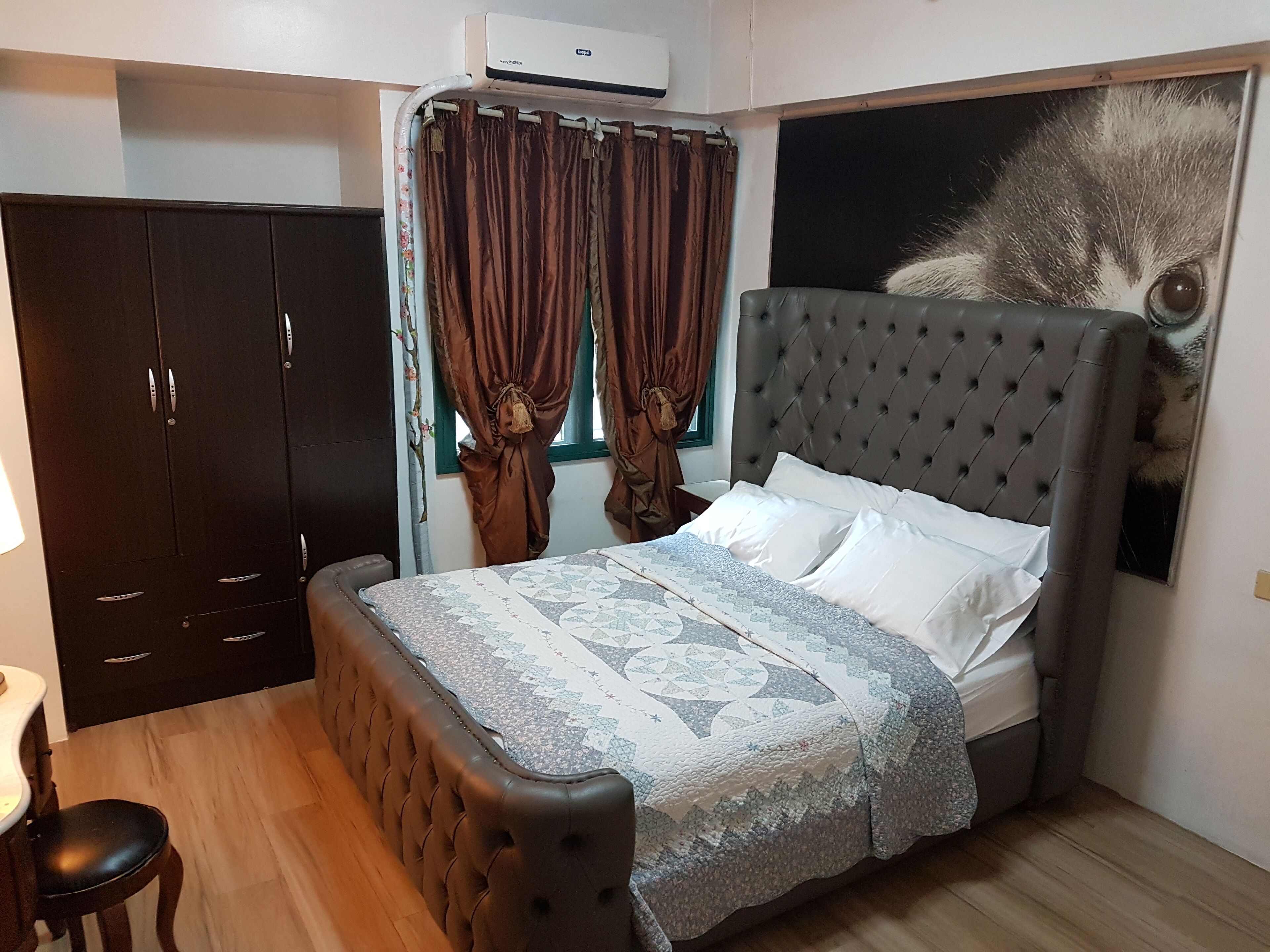 Ein Schlafzimmer mit einem Bett, einem Kleiderschrank und einem großen Poster an der Wand.