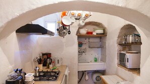 Una cocina compacta con estufa a gas, cafetera y microondas.