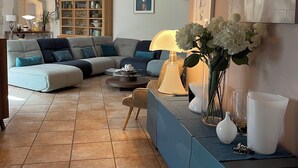 Un salon comprenant un canapé d’angle, une table basse et un buffet agrémenté d’objets décoratifs.