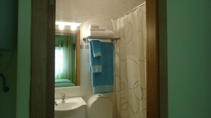 A bathroom with a sink, toilet, and shower curtain.