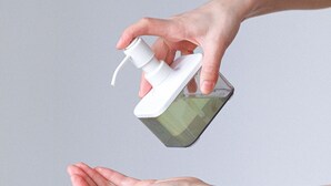 A hand dispensing liquid from a pump bottle.