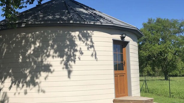 A small, single-story building with a curved roof and a wooden door. - Atypical gîte for 4 people 15 min from Angers (Saint-Martin-du-Fouilloux)