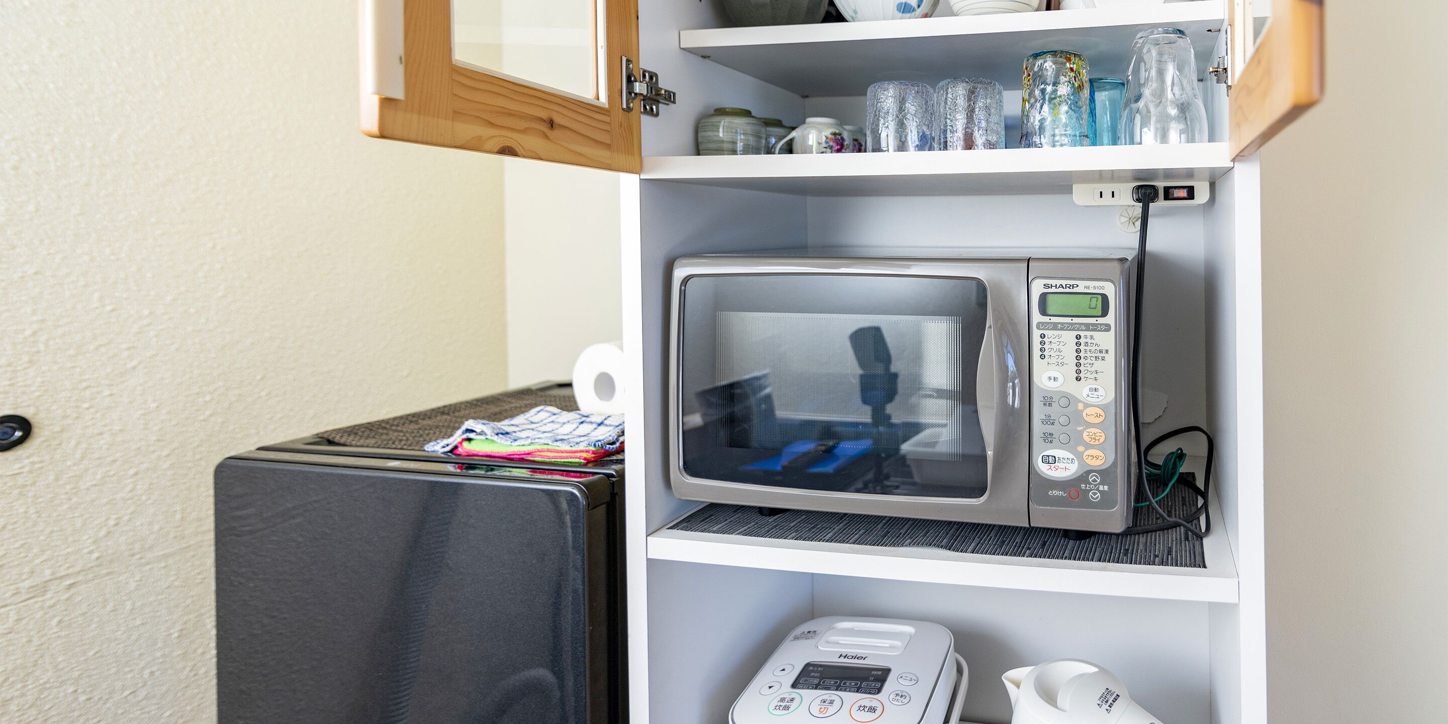 Une petite cuisine équipée d’un four à micro-ondes, d’un petit réfrigérateur et d’une machine à café.