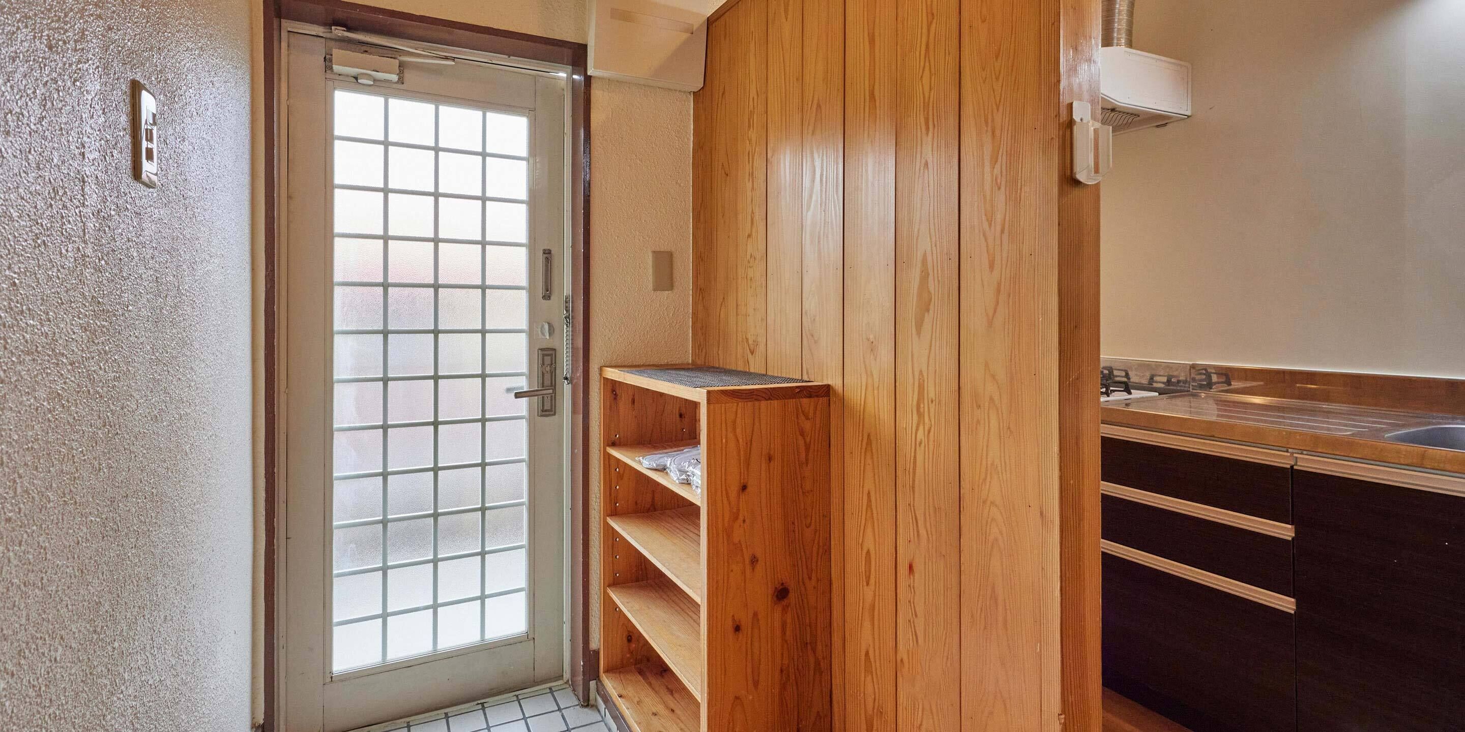 A bathroom with a wooden vanity, a sink, and a glass door.