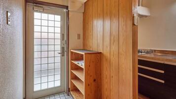 A bathroom with a wooden vanity, a sink, and a glass door.