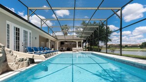 Una piscina con sillones de descanso y una zona cubierta.