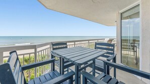 A balcony with a table and chairs, overlooking a beach. - Cozy Corner Unit, Jacuzzi Tub and Recliner, Lazy River | Crescent Shores - S 312 (North Myrtle Beach)