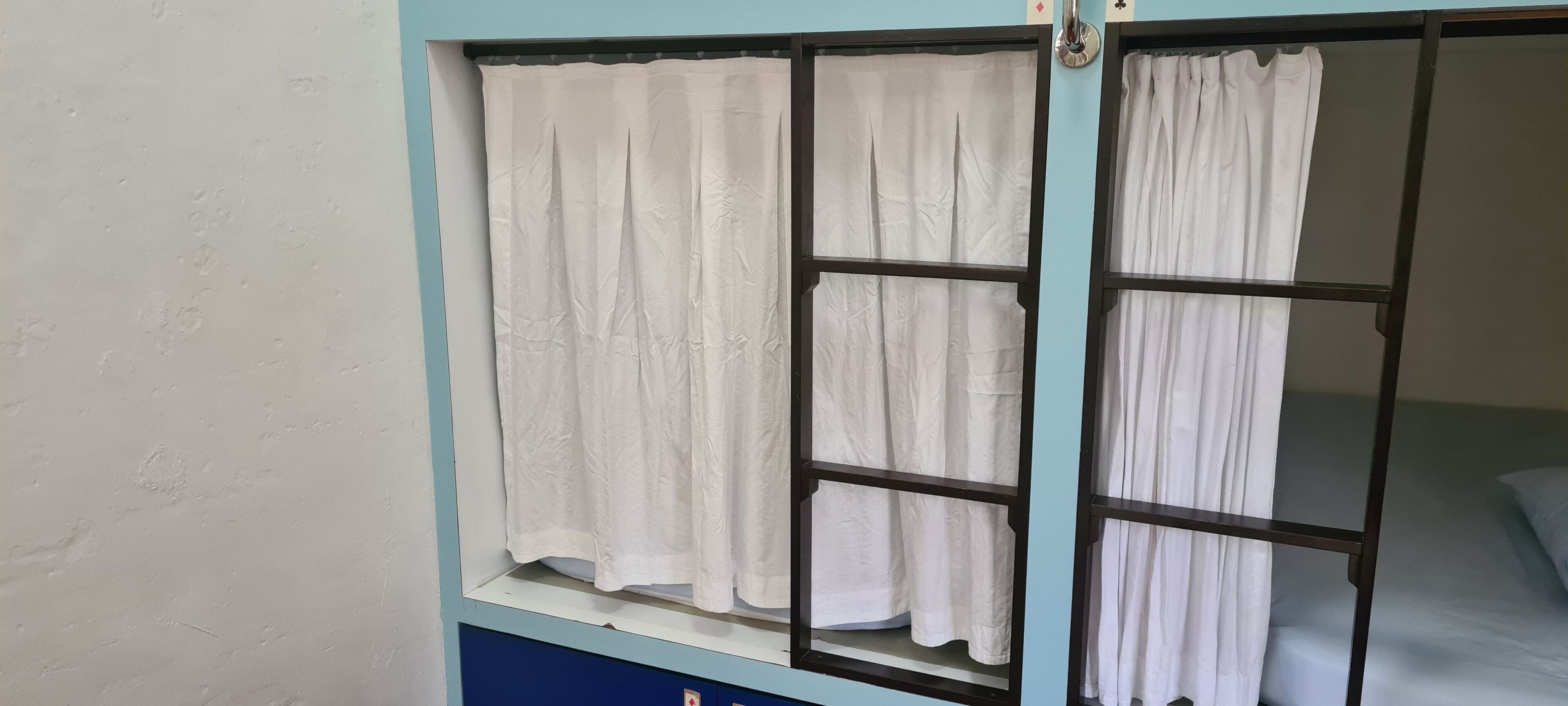 Ein Fenster mit weißen Vorhängen und Metallrahmen.