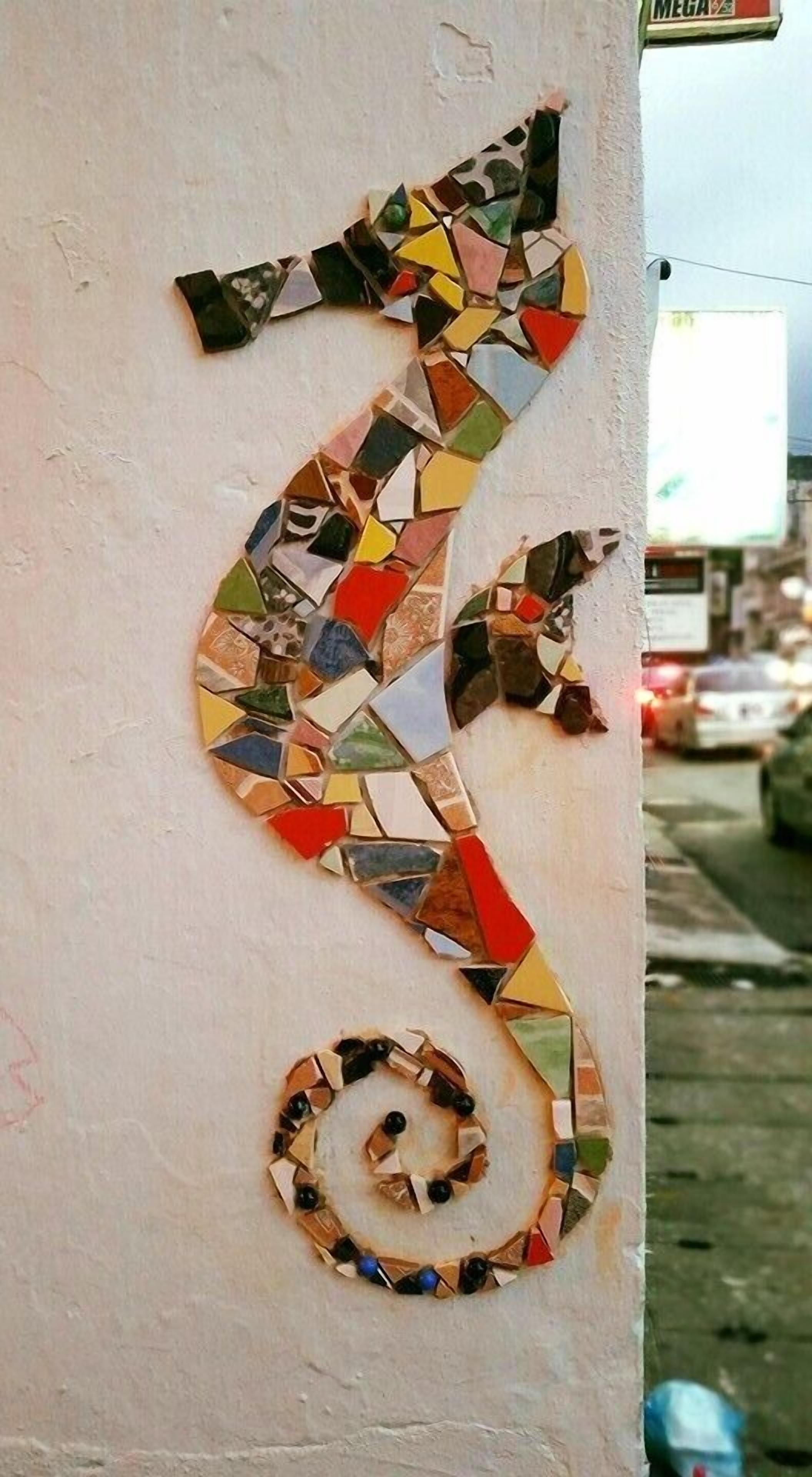 Un mosaico de un caballito de mar en una pared.