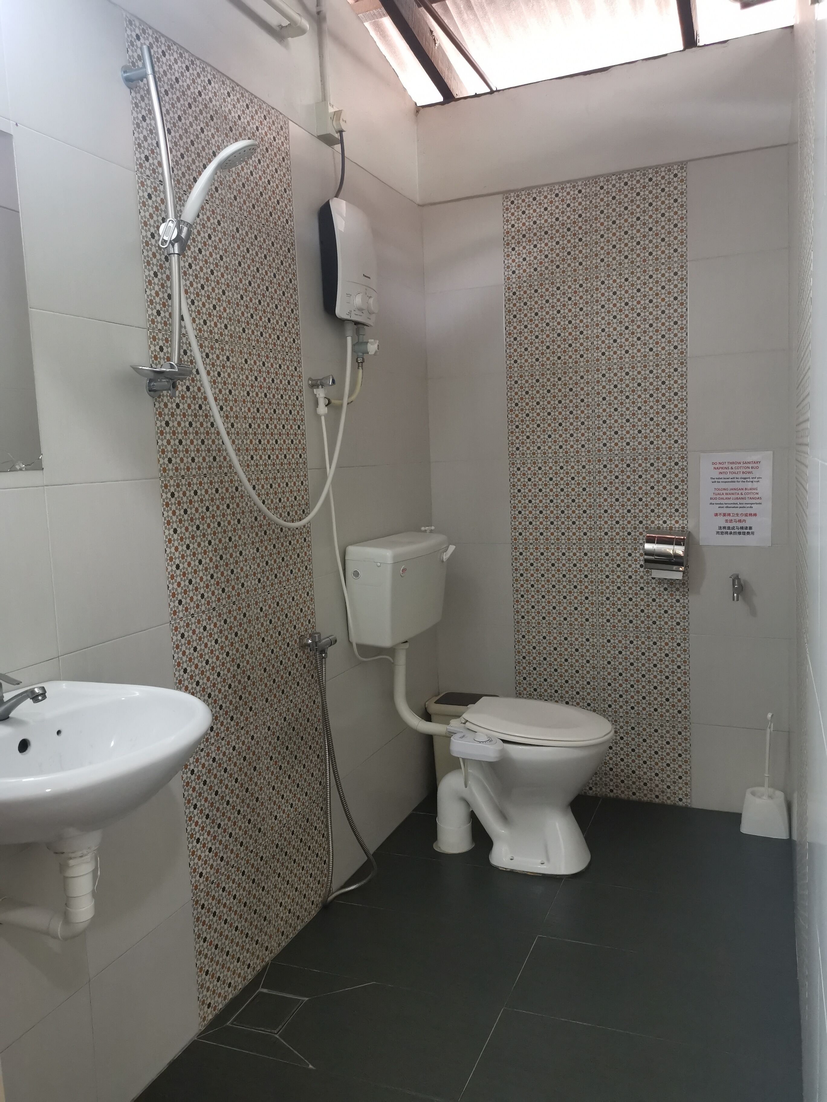 Un baño pequeño con inodoro, lavamanos y ducha.