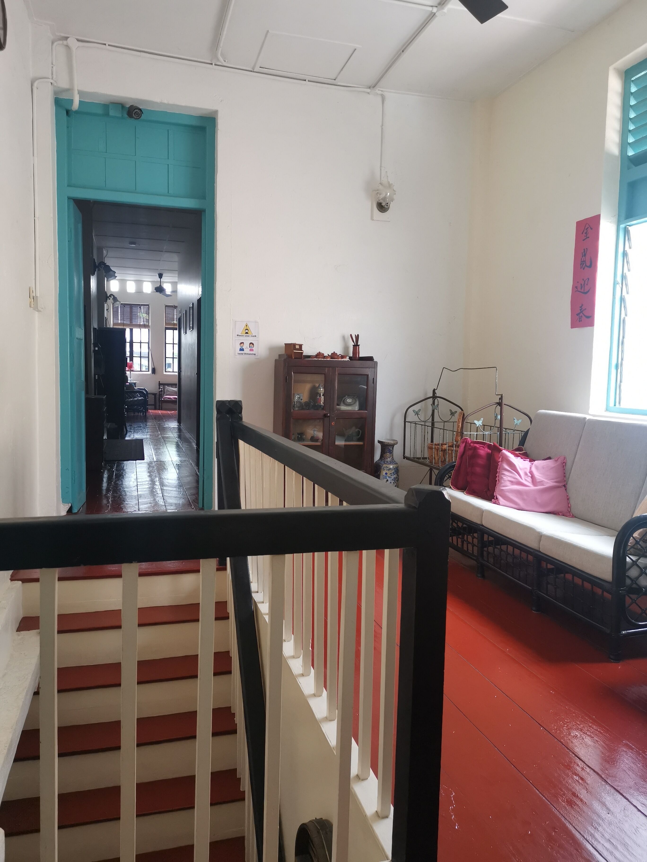 Una escalera con barandillas rojas y blancas que lleva a una habitación con un sofá y una ventana.