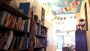 Una biblioteca con estanterías, un suelo a cuadros y un techo decorado con banderas.