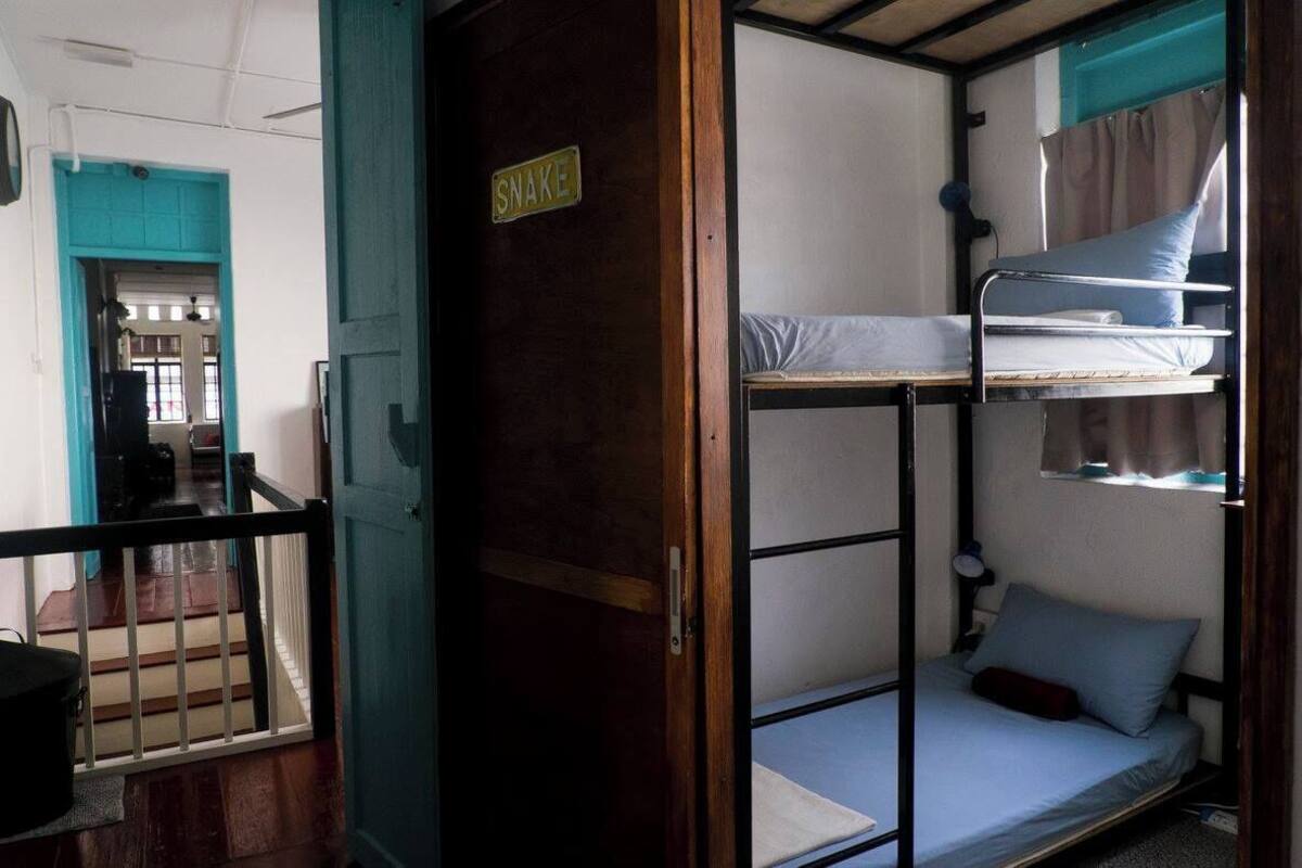 A bunk bed room with a sign that reads "SNAKE" on the door.