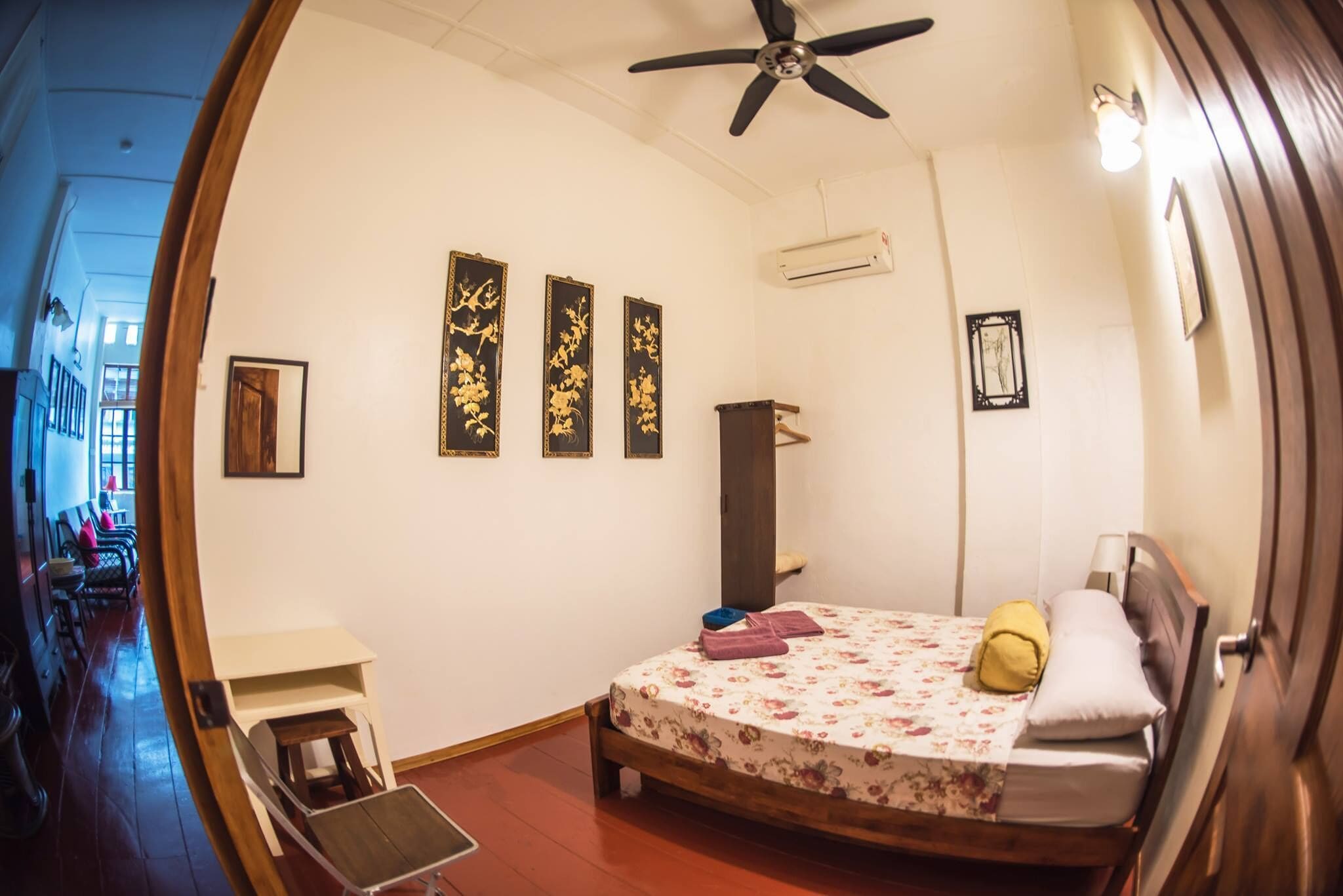 Une chambre à coucher avec un lit, un ventilateur de plafond et un climatiseur fixé au mur.