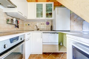 Equipped with an oven, dishwasher, and refrigerator, this kitchen offers a convenient cooking space.
