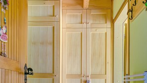 Une porte en bois avec une poignée, un sol carrelé et un radiateur sur le côté droit.
