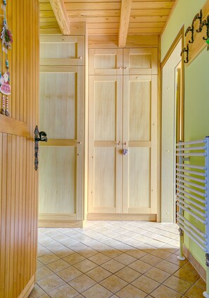 Stylish hallway leads to a door with a simple design, featuring a radiator and a light-colored tile floor.