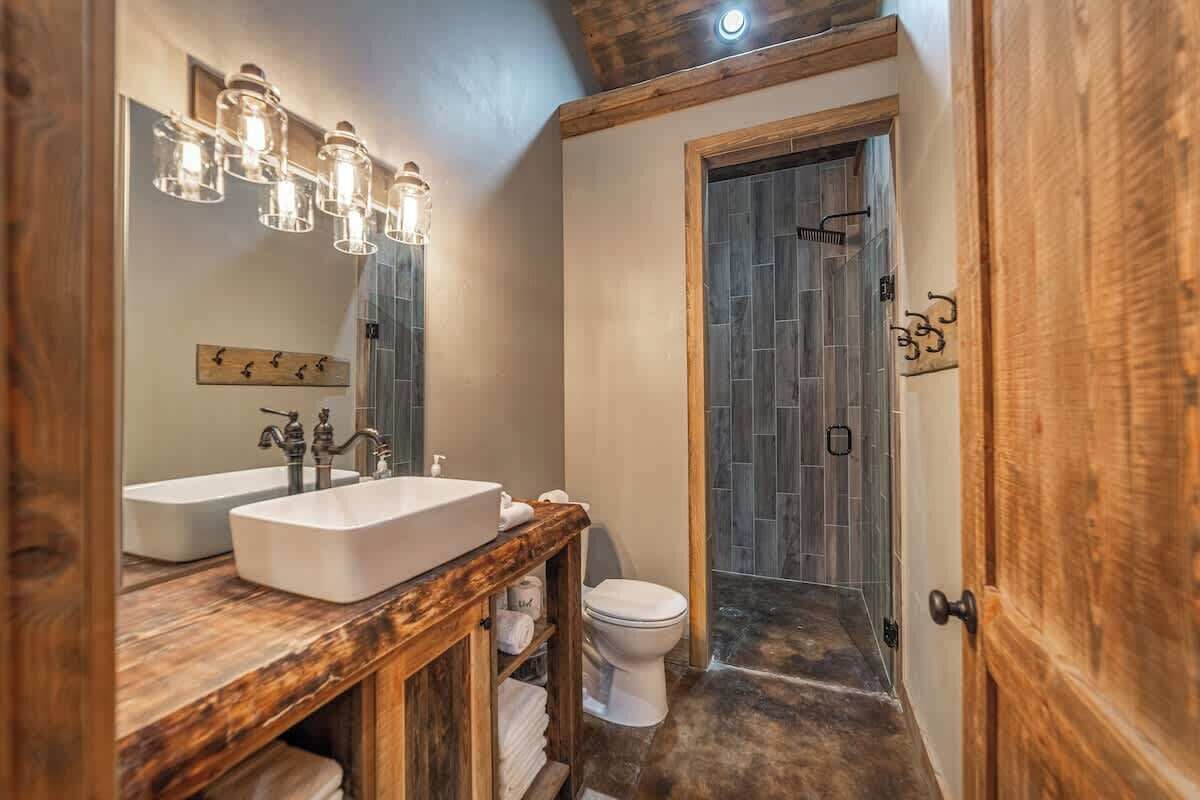 A bathroom with two sinks, a toilet, and a shower area.