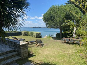 A patio with stone steps leading to a seating area overlooking a body of water. - "Heaven's door", exceptional villa feet in the water, direct access to the sea (Sarzeau)