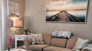 Ein Wohnzimmer mit einer Couch, einem Couchtisch und Kunstwerken an den Wänden.