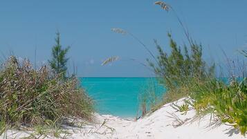 A beach with white sand and clear turquoise water.