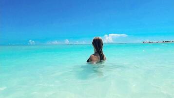 Rannalla, aurinkotuoleja, rantapyyhkeitä