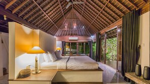 Quarto com cama, mesas de cabeceira, luminárias e vista para o exterior.