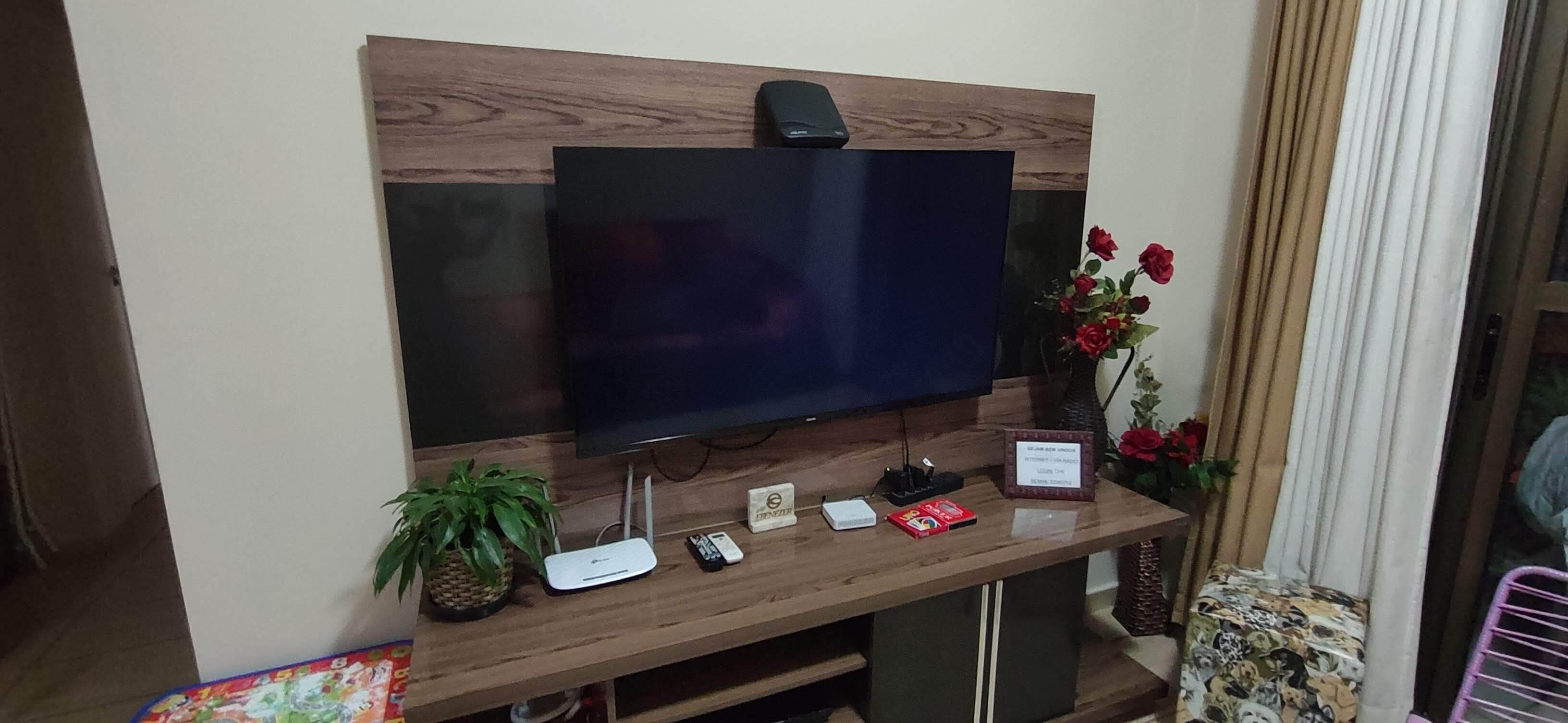 A flat-screen TV mounted on a wooden wall with a wooden panel design.