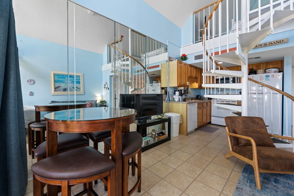 Un apartamento moderno con comedor, cocina y una escalera espiral.