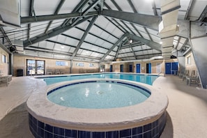 An indoor swimming pool with a hot tub, a covered roof, and a view of the outside. - Coastal Getaway | Sleeps 6 | Sport Courts, Community Pools, Beach Access (Gulf Shores)