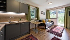 A compact living space with a kitchenette, a dining area, and a sofa. - Apartment Unterlechnung in Vomp (Vomp)