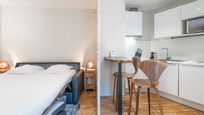 A modern hotel room with a bed, bedside table, lamp, and a small kitchenette. - Comfortable and clear studio in the heart of Bordeaux (Bordeaux)