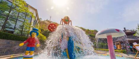 Un espace de jeux aquatiques comprenant une grande structure gonflable et une fontaine.
