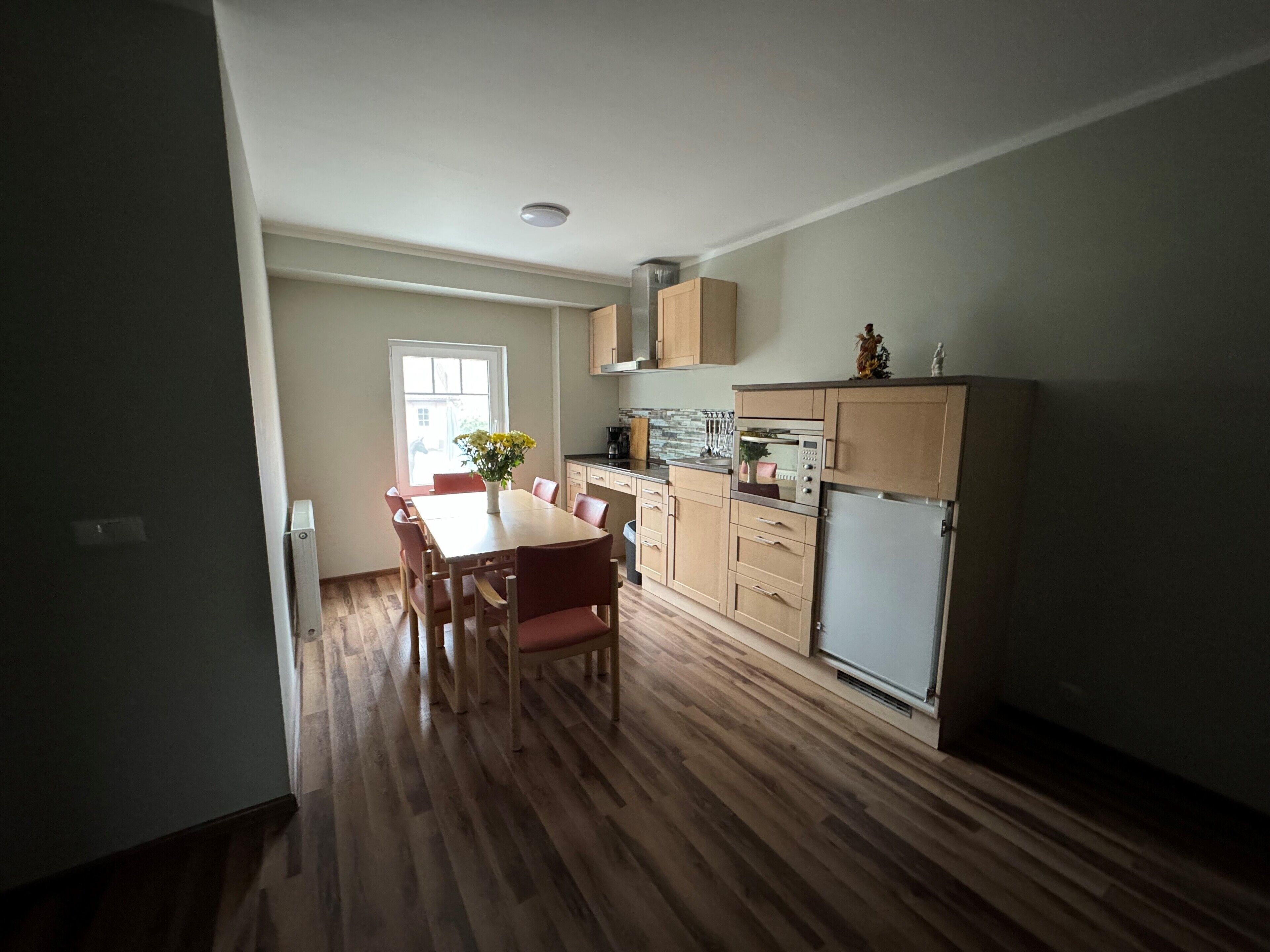 A compact kitchen with wooden cabinets, a built-in oven, and a refrigerator.