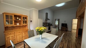 Une cuisine moderne avec un coin repas, des meubles en bois et un vase de fleurs jaunes sur la table.