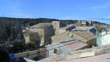 Une ville historique aux bâtiments en pierre, aux toits de tuiles et sous un ciel d’un bleu éclatant.