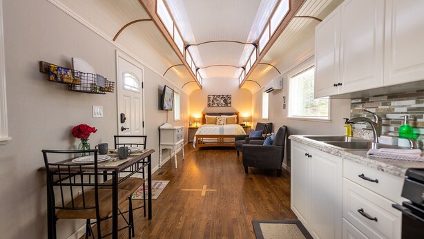 Une chambre d’hôtel compacte comprenant un coin cuisine, un espace repas et un lit.