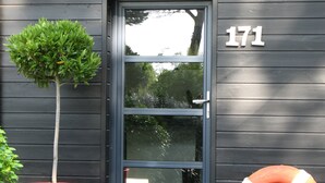 A door with the number 171, a potted tree, and a lifebuoy outside a building. - Seaway la Salorge de Lanseria (Mesquer)