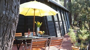An outdoor dining area with a table, chairs, a yellow umbrella, a vase with flowers, and potted plants. - Seaway la Salorge de Lanseria (Mesquer)