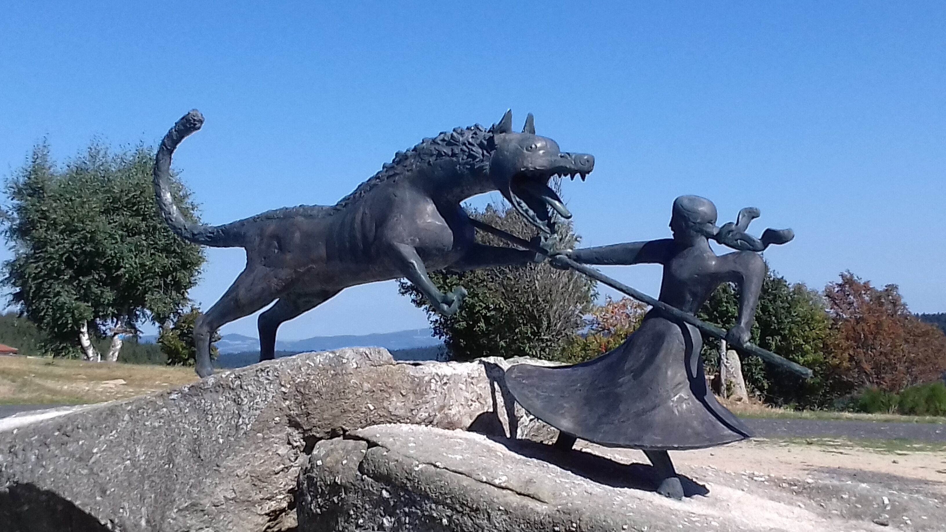 A sculpture of a horse and a human figure on a stone pedestal.