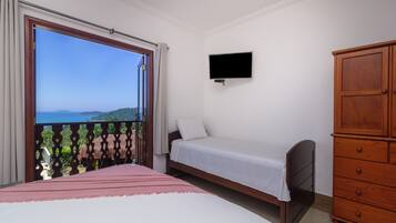 Ein Schlafzimmer mit Bett, Fernseher, Kleiderschrank und einem Balkon mit Aussicht.