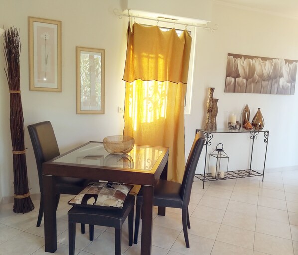 A dining area with a glass-top table, black chairs, a woven basket, and a yellow curtain. - On a magical peninsula, luxurious romantic flat, St Jean Cap Ferrat (Saint-Jean-Cap-Ferrat)