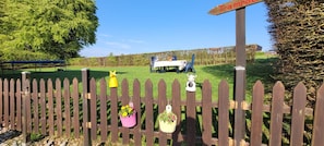 Ein Holzzaun mit Blumentöpfen und einem Schild, auf dem 'Trampoline' steht.